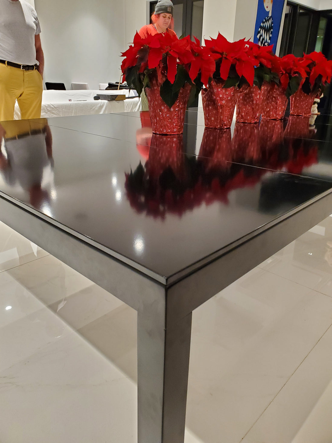 Modern pool table with red felt surface in a stylish room with chandelier and sofa.