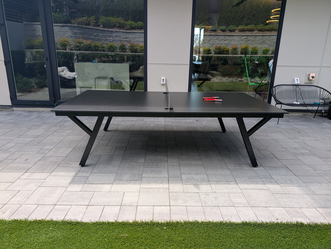 Modern outdoor patio with ping pong table, chairs, and garden view