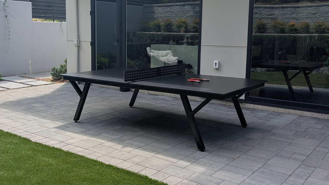Modern outdoor patio with ping pong table, chairs, and garden view