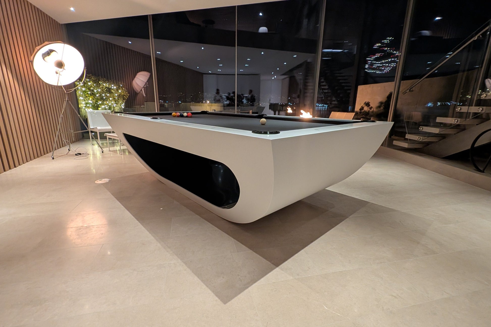 Modern pool table in a stylish room with large windows