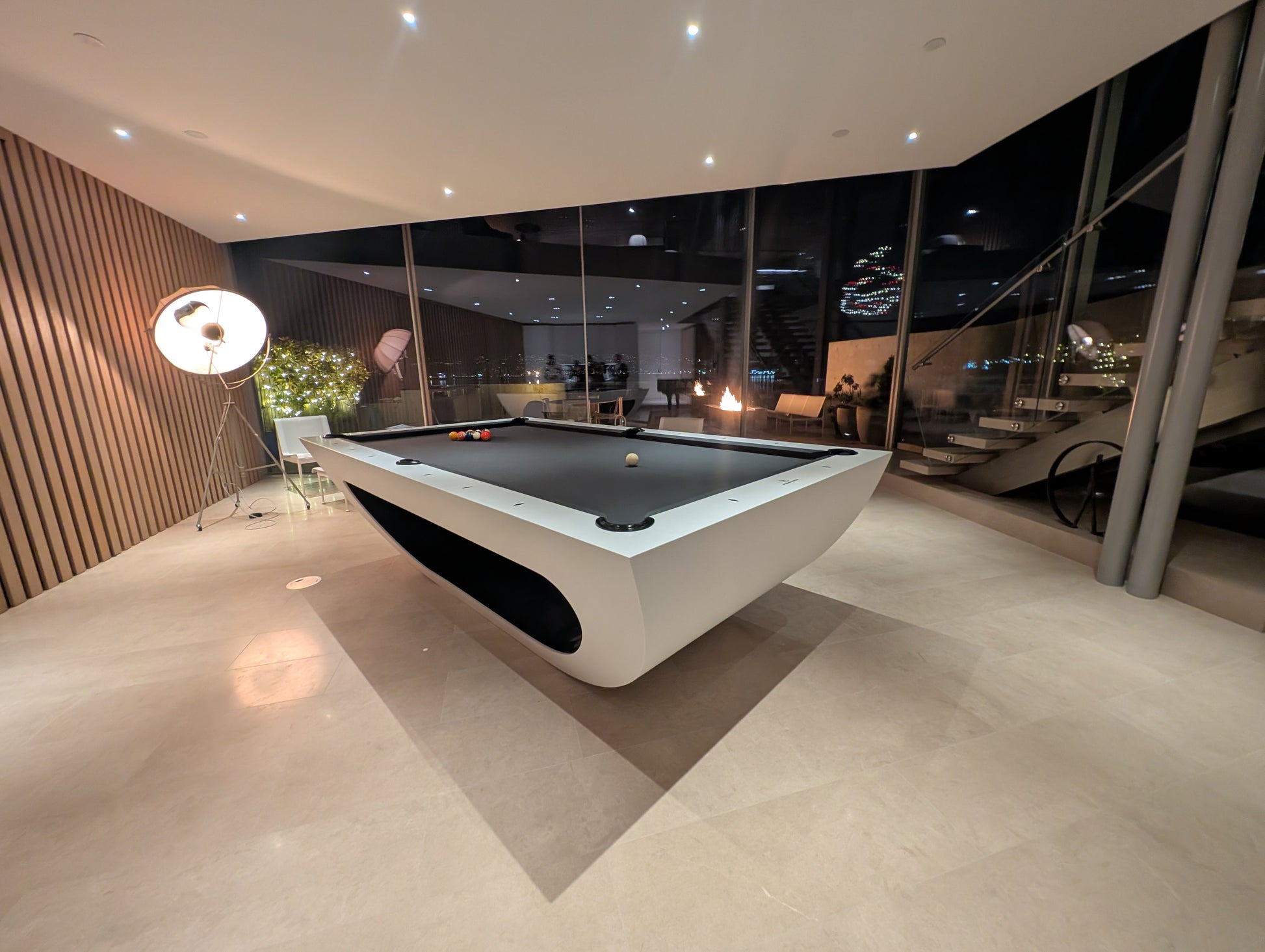 Modern pool table in a stylish room with large windows