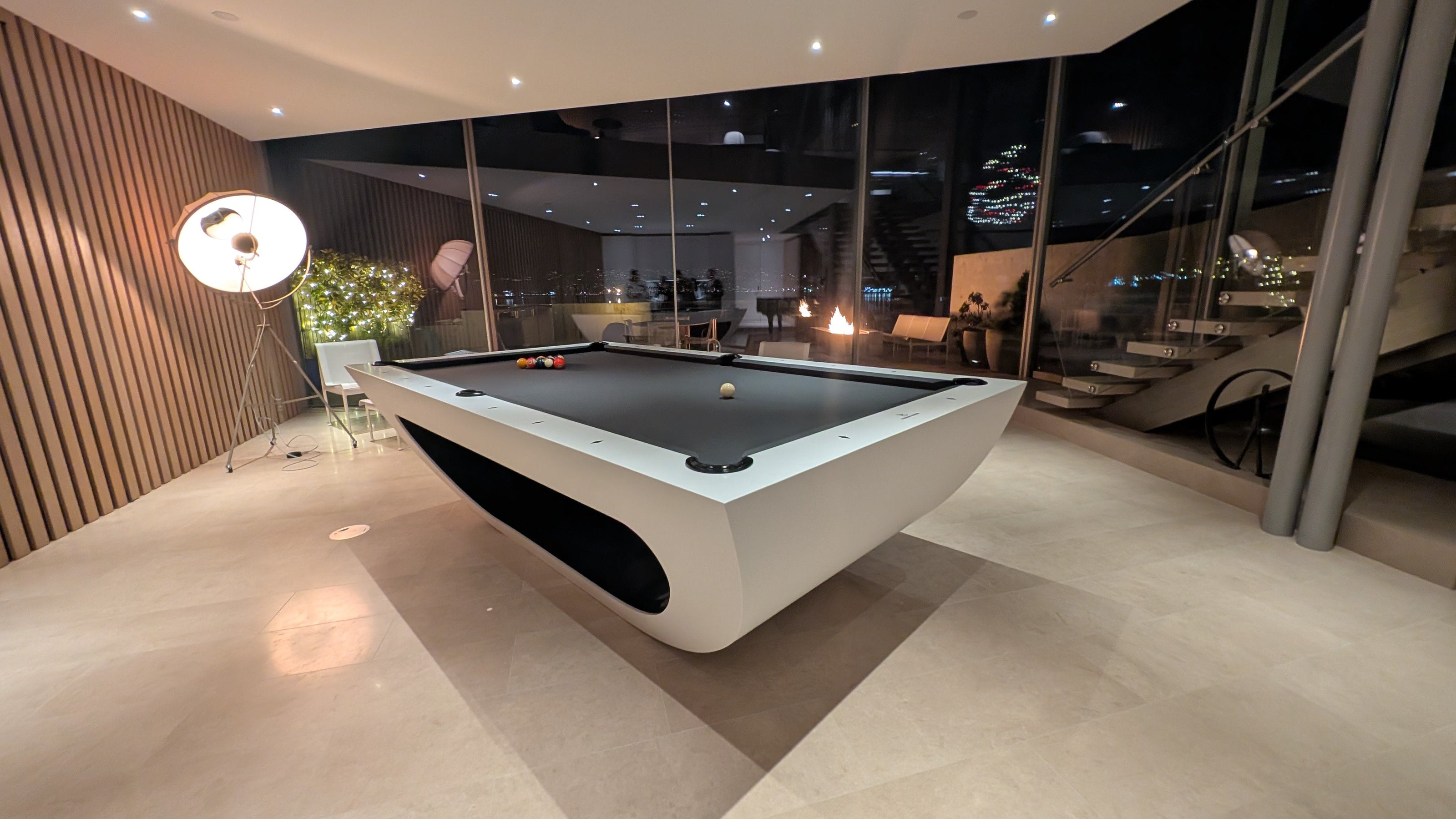 Modern pool table in a stylish room with large windows