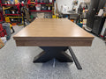 Wooden table with black metal base in a workshop setting