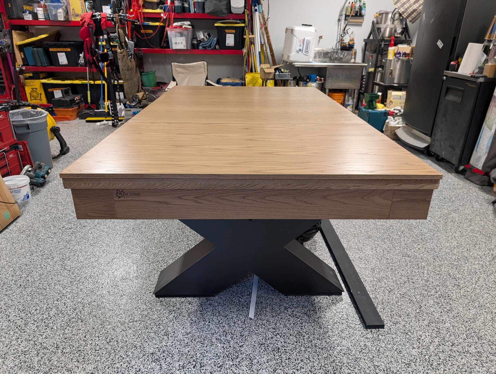 Wooden table with black metal base in a workshop setting