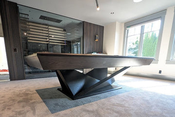 Modern pool table in a stylish living room with large windows